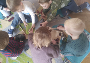 Dzieci bawiące się kasztanami, drewnianymi łyżkami i chwytakami