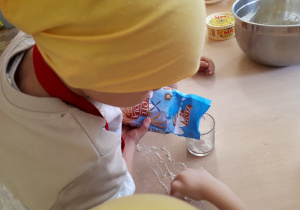 Dziecko odmierzające mąkę