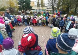 Dzieci i nauczycielki śpiewające Hymn Polski w ogrodzie