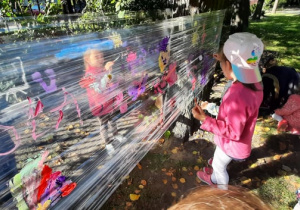 Dzieci tworzą zakropkowane obrazki w ogrodzie