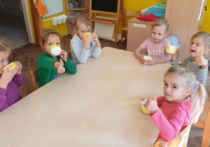 Dzieci piją samodzielnie zrobiony sok jabłkowy
