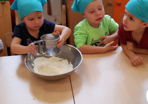 Dzieci przesiewają mąkę
