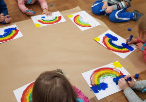 Dzieci malujące farbami tęczę