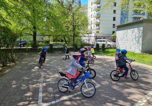 Dzieci jeżdżące na rowerach i hulajnogach