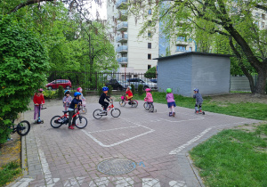 Dzieci jeżdżące na rowerach i hulajnogach