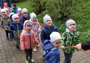 Dzieci idące na spacer, trzymające linę